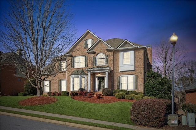 view of front of property featuring a front yard and brick siding