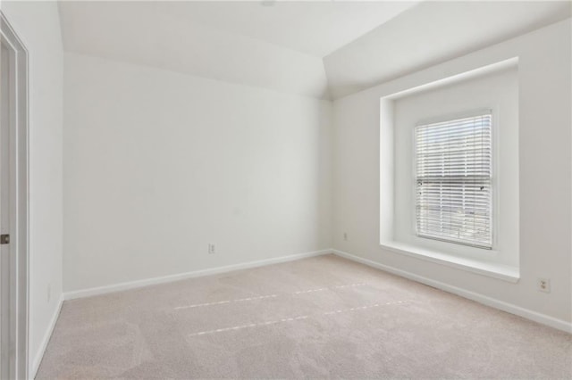 empty room with lofted ceiling, carpet, and baseboards