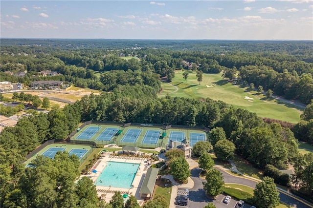 drone / aerial view featuring view of golf course and a wooded view