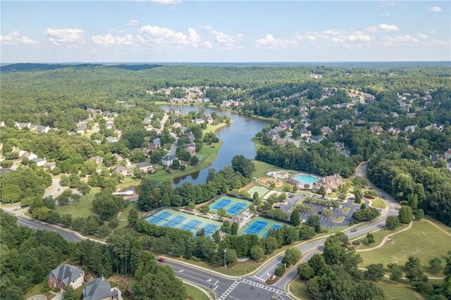 drone / aerial view with a water view and a view of trees