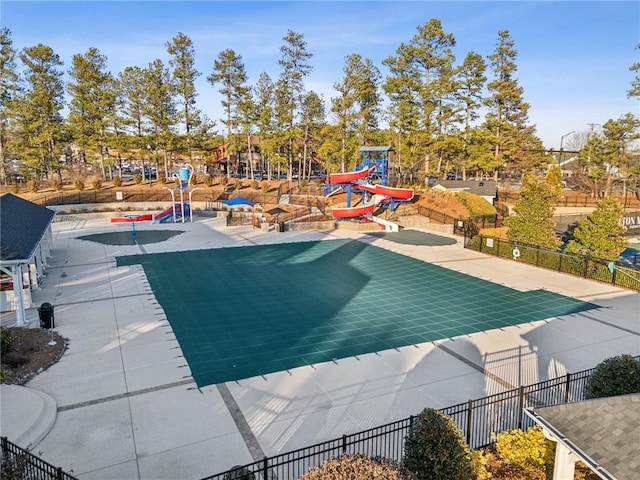 view of pool with a patio area, fence, and playground community