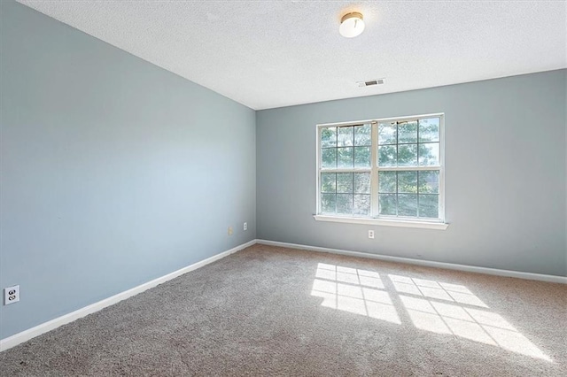 carpeted spare room featuring a textured ceiling