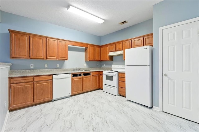 kitchen with white appliances, sink, and a textured ceiling