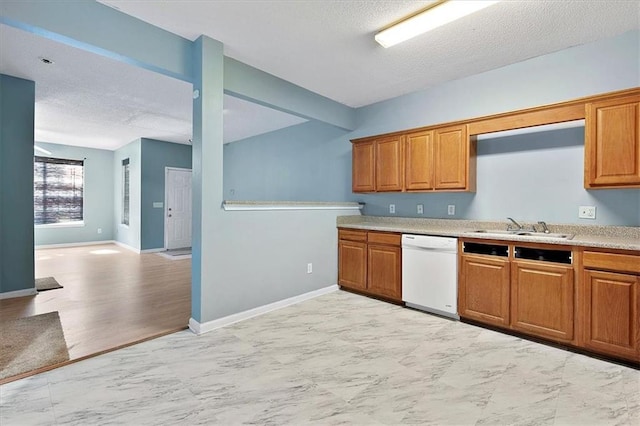 kitchen featuring white dishwasher, light hardwood / wood-style floors, sink, and a textured ceiling