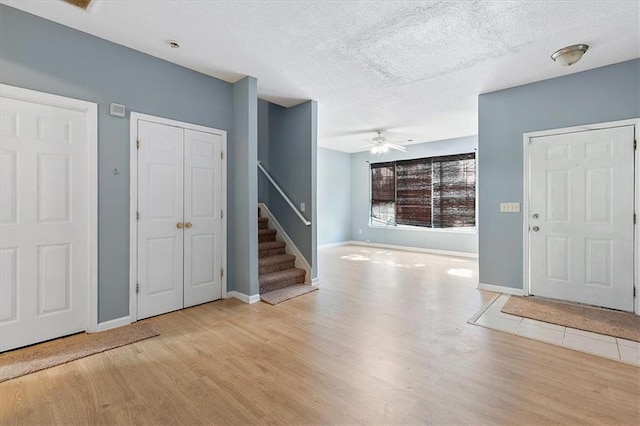 foyer entrance featuring light wood-type flooring, ceiling fan, and a textured ceiling