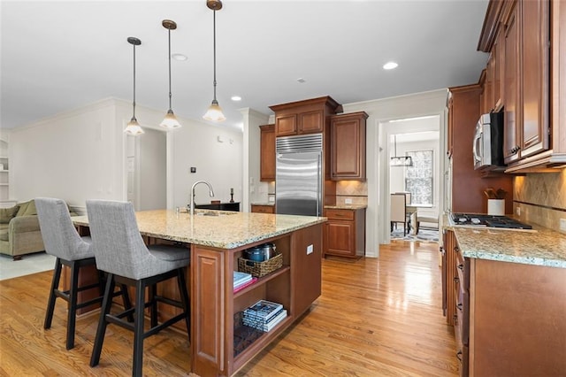 1215 Renaissance Ct SE, Mableton, GA 30126 - kitchen with appliances with stainless steel finishes, light wood finished floors, a kitchen bar, decorative backsplash, and light stone counters