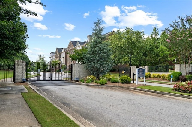 1215 Renaissance Ct SE, Mableton, GA 30126 - view of asphalt road featuring a gate, curbs, a gated entry, and sidewalks