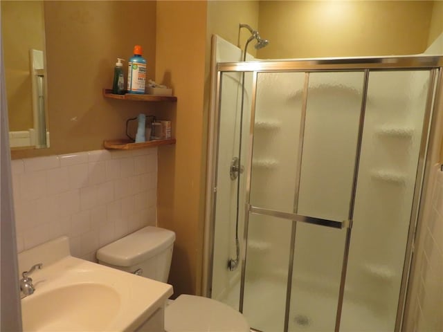5586 Kingsport Dr, Atlanta, GA 30342 - bathroom featuring tile walls, vanity, a shower with door, and toilet