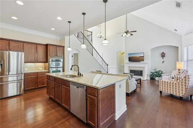 kitchen featuring sink, dark hardwood / wood-style flooring, high vaulted ceiling, a kitchen island with sink, and appliances with stainless steel finishes