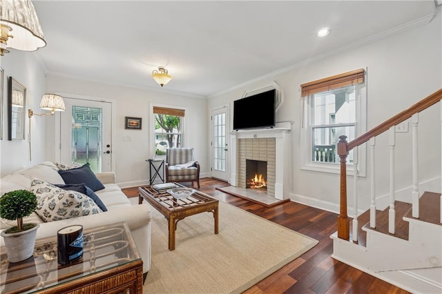 183 Whitefoord Ave NE, Atlanta, GA 30307 - living room featuring stairs, a brick fireplace, dark wood-style floors, ornamental molding, and baseboards
