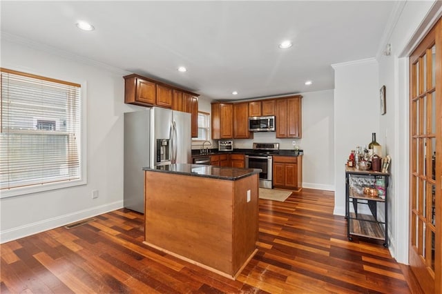 183 Whitefoord Ave NE, Atlanta, GA 30307 - kitchen with appliances with stainless steel finishes, ornamental molding, baseboards, dark wood-type flooring, and a kitchen island
