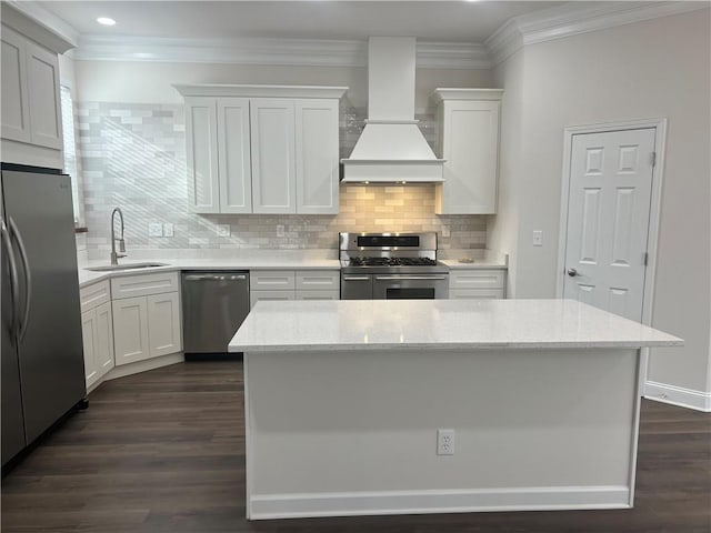 kitchen with crown molding, premium range hood, dark wood-style flooring, appliances with stainless steel finishes, and a sink