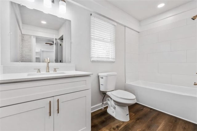 bathroom with vanity, wood finished floors, baseboards, bathtub / shower combination, and toilet