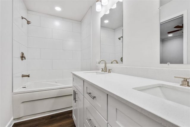 full bathroom featuring double vanity, wood finished floors, bathing tub / shower combination, and a sink