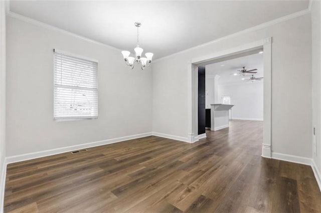 empty room featuring dark wood-type flooring, ceiling fan with notable chandelier, baseboards, and ornamental molding