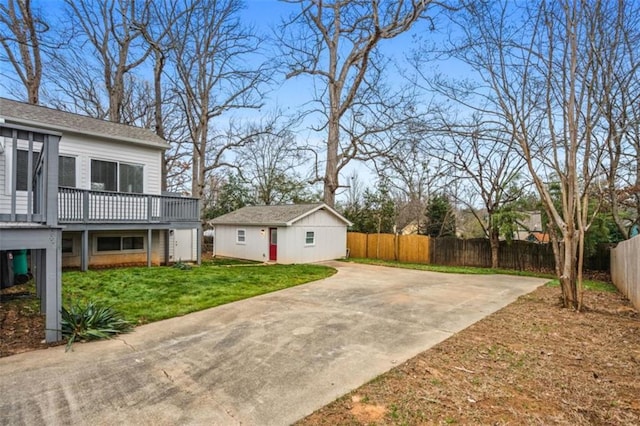 view of yard featuring a deck, an outdoor structure, and fence