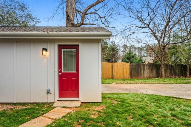 property entrance featuring a lawn and fence