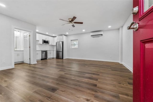 unfurnished living room with dark wood-style floors, recessed lighting, a wall mounted air conditioner, and ceiling fan