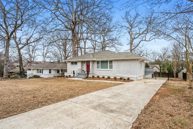 view of front of property with brick siding, fence, concrete driveway, a front yard, and a gate