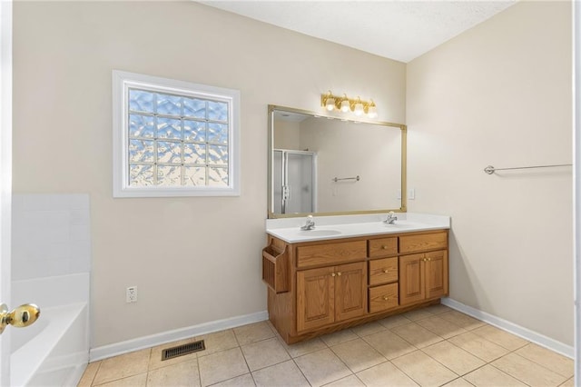 bathroom with double vanity, baseboards, a sink, and a bath