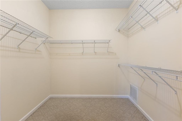 walk in closet featuring carpet flooring and visible vents