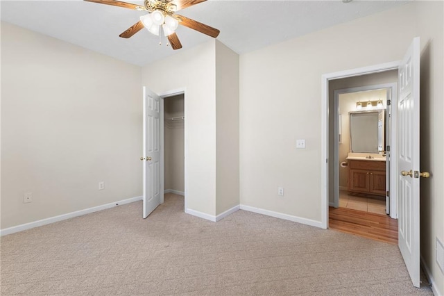 unfurnished bedroom with a closet, light colored carpet, ceiling fan, and baseboards