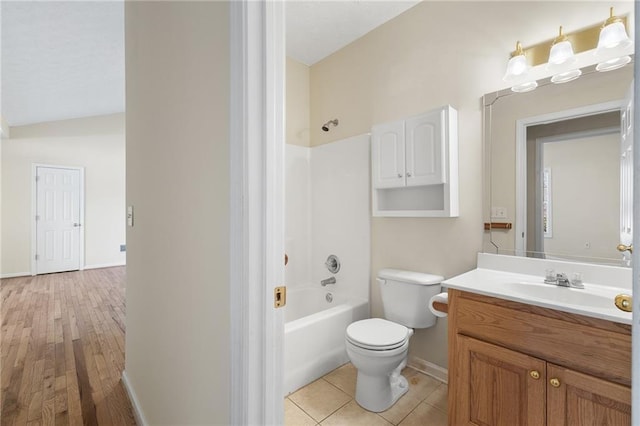 bathroom with toilet, vanity, baseboards, shower / washtub combination, and tile patterned floors