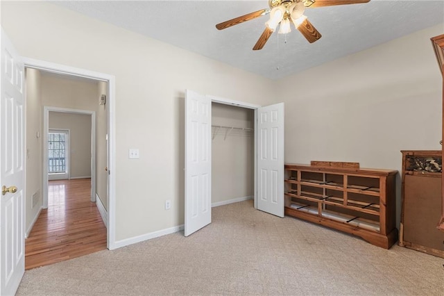 unfurnished bedroom featuring carpet floors, a closet, baseboards, and a ceiling fan