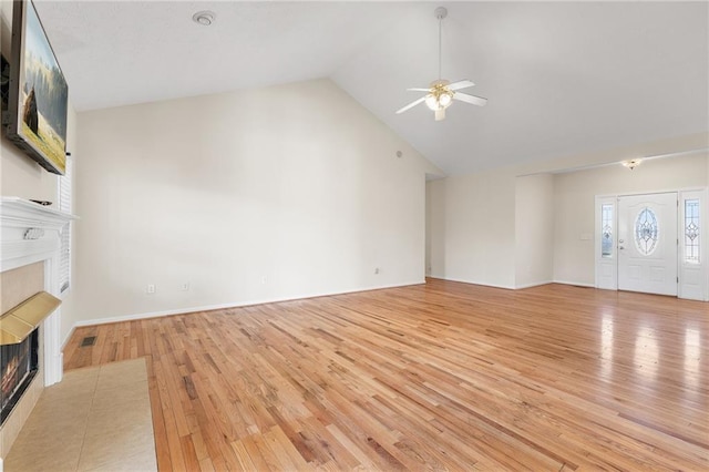 unfurnished living room featuring visible vents, a ceiling fan, high vaulted ceiling, light wood-type flooring, and a tile fireplace