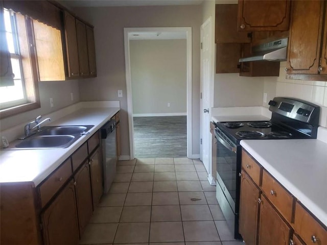 kitchen featuring stainless steel appliances, sink, and light tile patterned floors