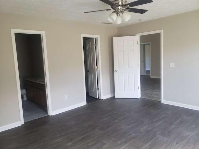 unfurnished bedroom with connected bathroom, a closet, dark hardwood / wood-style floors, and ceiling fan