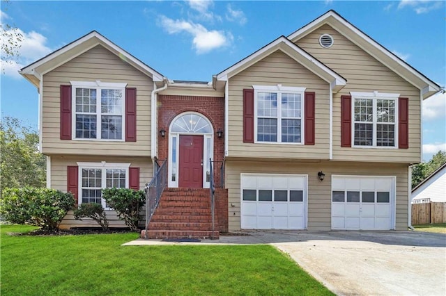 raised ranch featuring a garage and a front yard