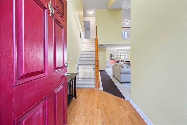 entryway with light hardwood / wood-style flooring and a notable chandelier