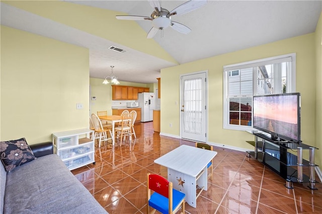 tiled living room with vaulted ceiling and ceiling fan with notable chandelier