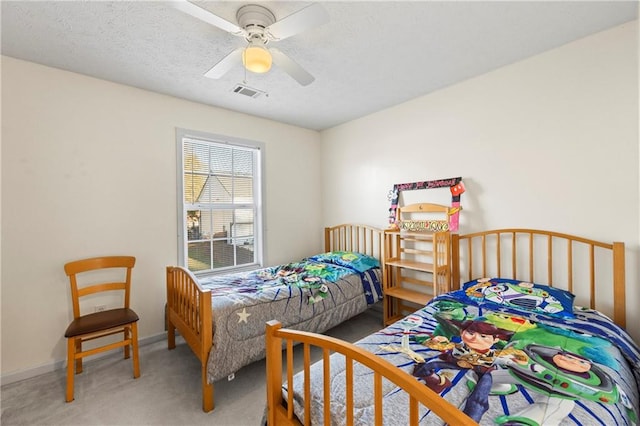 carpeted bedroom featuring ceiling fan and a textured ceiling