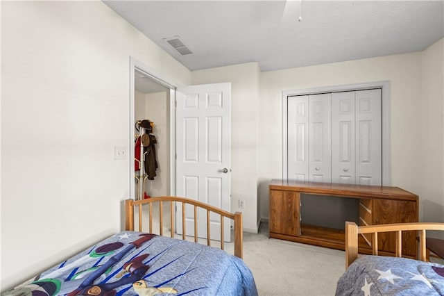 bedroom with ceiling fan, light colored carpet, and a closet