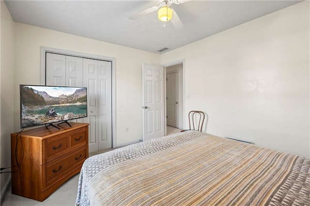 bedroom with ceiling fan, a closet, and light carpet