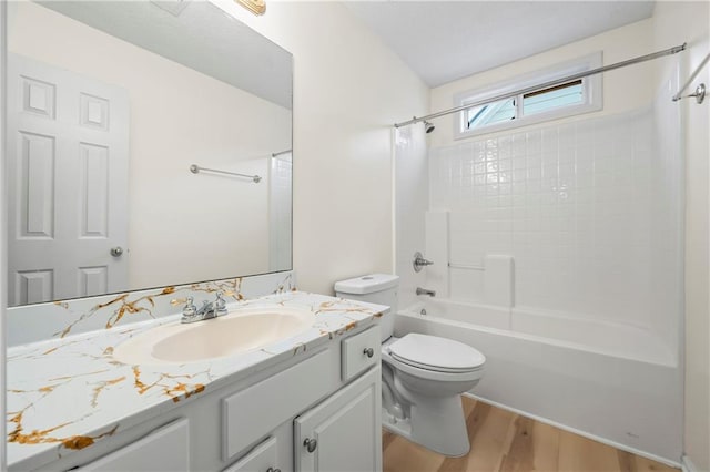 full bathroom featuring toilet, vanity,  shower combination, and hardwood / wood-style flooring