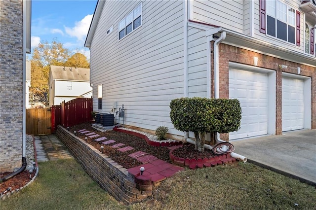 view of property exterior with central air condition unit and a garage