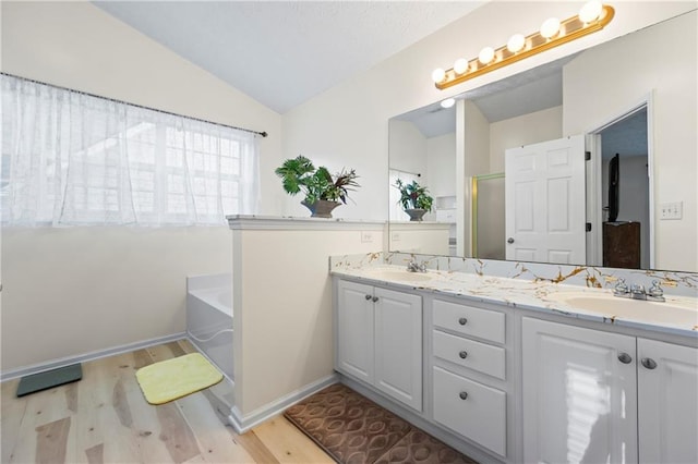 bathroom featuring hardwood / wood-style floors, vanity, independent shower and bath, and lofted ceiling