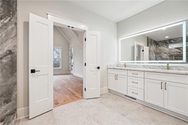 bathroom featuring vanity and lofted ceiling