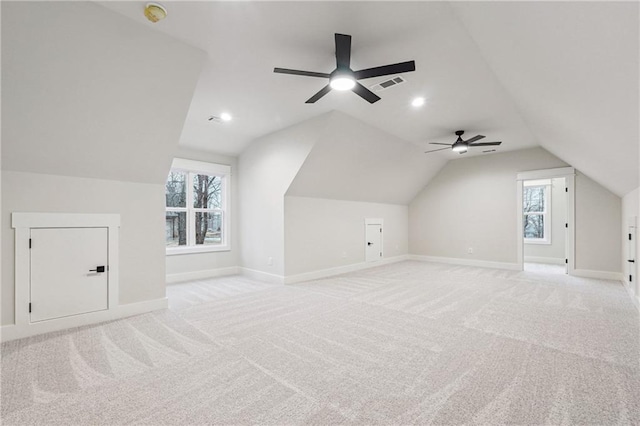 additional living space featuring a wealth of natural light, light colored carpet, and vaulted ceiling