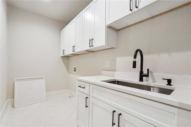 clothes washing area with cabinets, hookup for a washing machine, and sink