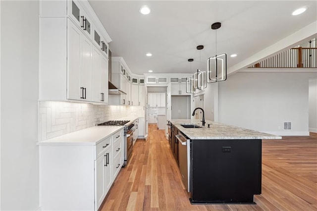 kitchen featuring white cabinetry, appliances with stainless steel finishes, sink, and an island with sink