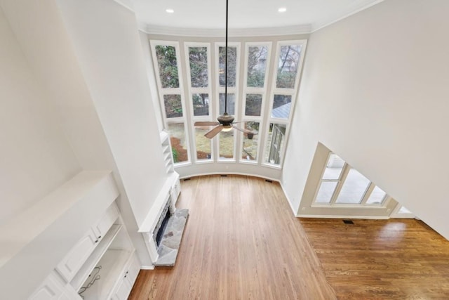 unfurnished living room with recessed lighting, ornamental molding, and wood finished floors