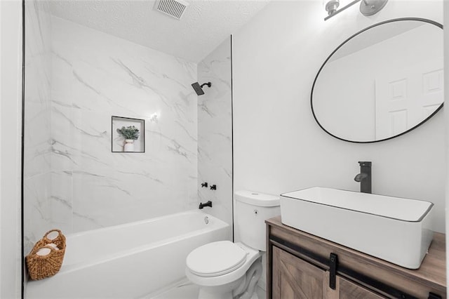 full bathroom with tiled shower / bath, vanity, a textured ceiling, and toilet