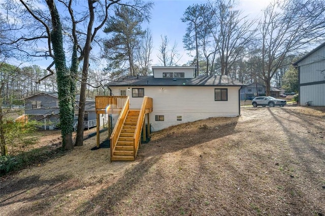 rear view of property featuring a wooden deck