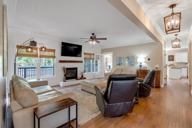 87 Washington Blvd, Dallas, GA 30132 - living room featuring ornamental molding, a chandelier, light wood finished floors, a ceiling fan, and a large fireplace