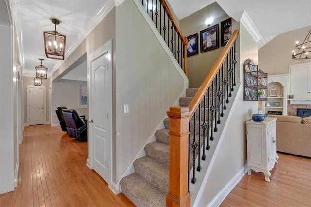 87 Washington Blvd, Dallas, GA 30132 - stairway featuring a chandelier, hardwood / wood-style flooring, crown molding, baseboards, and a stone fireplace