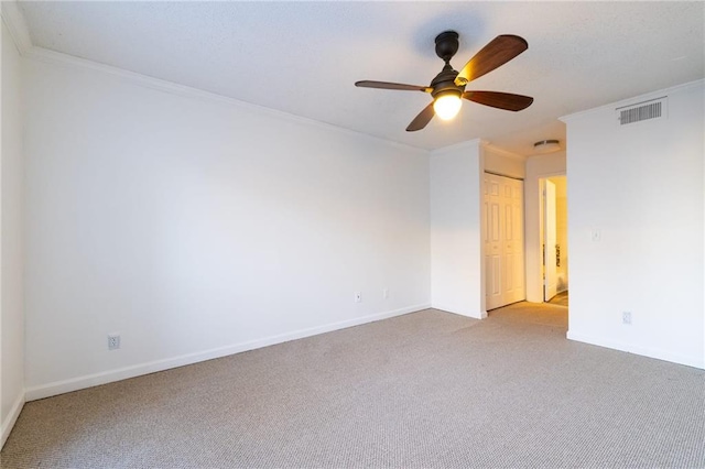 carpeted spare room featuring ceiling fan and ornamental molding